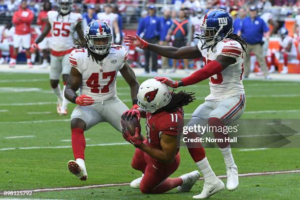 Wide receiver Larry Fitzgerald of the Arizona Cardinals makes a catch between linebacker Kelvin Sheppard and defensive back Brandon Dixon of the New...