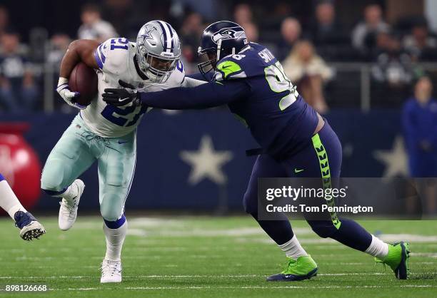 Ezekiel Elliott of the Dallas Cowboys tries to evade tackle by Garrison Smith of the Seattle Seahawks in the second quarter of a football game at...