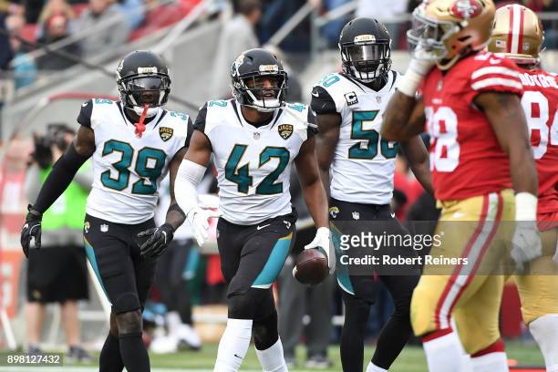 Barry Church of the Jacksonville Jaguars celebrates with Tashaun Gipson and Telvin Smith of the Jacksonville Jaguars after an interception of Jimmy...