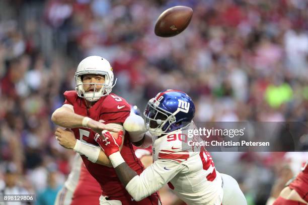 Quarterback Drew Stanton of the Arizona Cardinals is hit by defensive end Jason Pierre-Paul of the New York Giants while throwing a pass in the first...