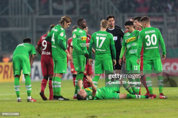 Referee Manuel Graefe speaks with players of Moenchengladbach during the DFB Cup match between Borussia Moenchengladbach and Bayer Leverkusen at...