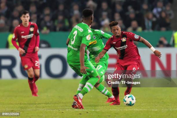 Leon Bailey of Leverkusen, Mickael Cuisance of Moenchengladbach and Reece Oxford battle for the ball during the DFB Cup match between Borussia...