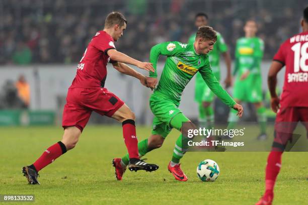 Mickael Cuisance of Moenchengladbach and Sven Bender of Leverkusen battle for the ball during the DFB Cup match between Borussia Moenchengladbach and...