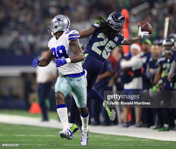 Richard Sherman of the Seattle Seahawks tries to grab a ball intended for Dez Bryant of the Dallas Cowboys in the first half of a football game at...