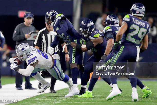Ezekiel Elliott of the Dallas Cowboys is tackled by Byron Maxwell of the Seattle Seahawks and Sheldon Richardson of the Seattle Seahawks in the...
