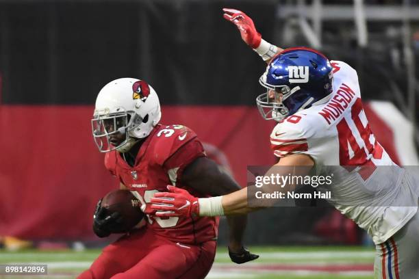 Running back Kerwynn Williams of the Arizona Cardinals runs with the football against middle linebacker Calvin Munson of the New York Giants in the...