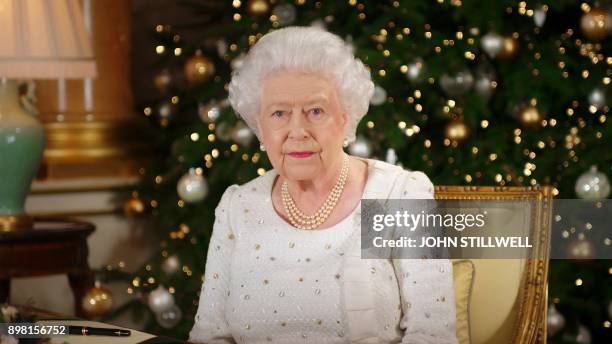 Britain's Queen Elizabeth II poses at a desk in the 1844 Room at Buckingham Palace, London, on December 13, 2017 after recording her Christmas Day...