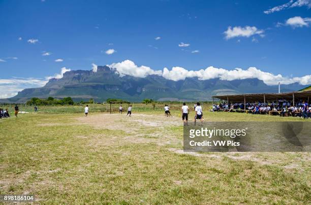 Some students from the school of Kamarata, located in the national park Canaima, Venezuela play a soccer game, in their field of sports having...