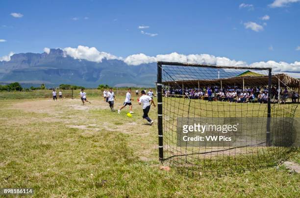 Some students from the school of Kamarata, located in the national park Canaima, Venezuela play a soccer game, in their field of sports having...
