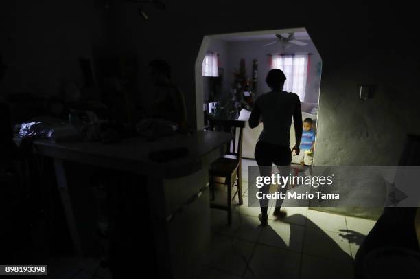 Member of the Medina family holds her cell phone for light before dinner on Christmas Eve on December 24, 2017 in San Isidro, Puerto Rico. Most of...