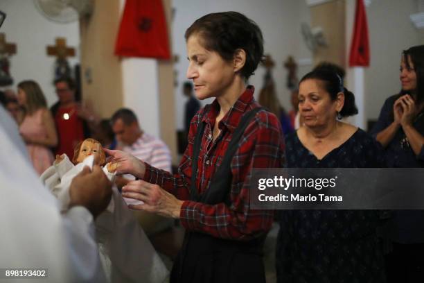 Faithful wait to touch a doll depicting Jesus Christ during 'midnight mass' at the Nuestra Senora Del Carmen Church on Christmas Eve on December 24,...