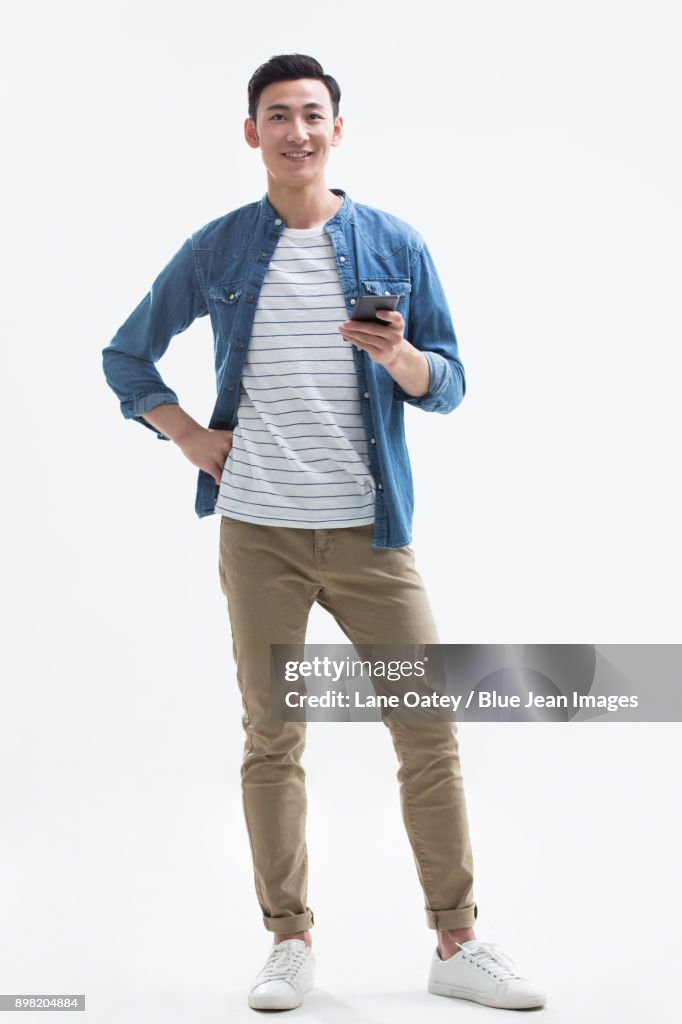 Cheerful young man holding a smart phone