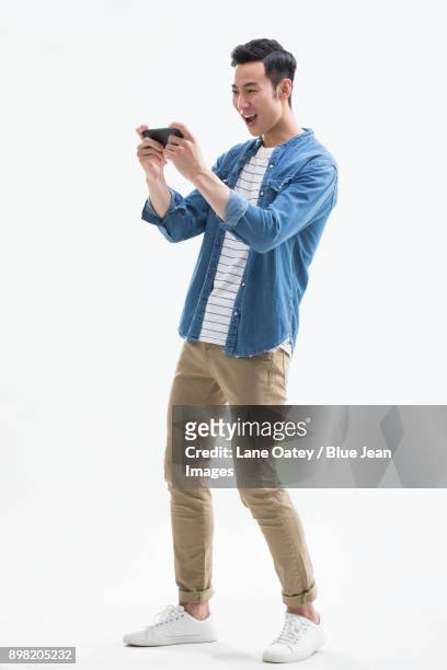 young man playing mobile games - asian watching movie stockfoto's en -beelden