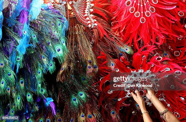 Woman from the Bachanal Mas carnival band tries on part of her costume ahead of the annual Notting Hill carnival on August 15, 2009 in London,...