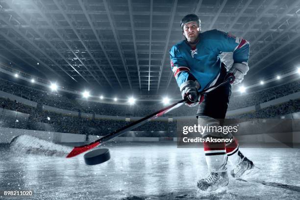 ice hockey player on big professional ice arena - puck stock pictures, royalty-free photos & images