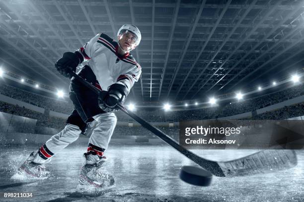 ice hockey player on big professional ice arena - hockey puck stock pictures, royalty-free photos & images