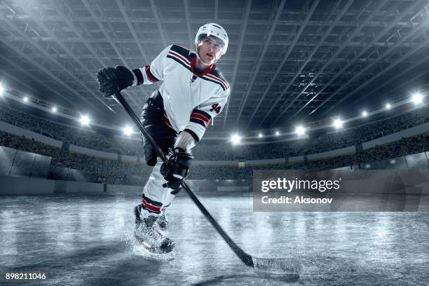 ice hockey player on big professional ice arena - hockey player puck stock pictures, royalty-free photos & images