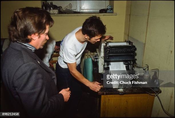 Polish trade-unionist Lech Walesa watches as an unidentified man operates a small printing press at Solidarity headquarters, Gdansk, Poland, December...