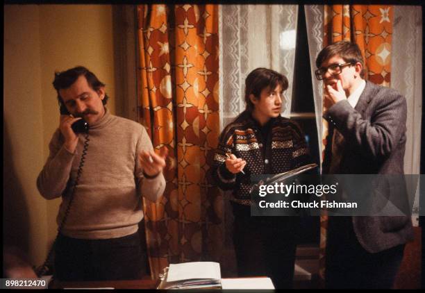 Polish trade-unionist Lech Walesa talk on the telephone as his secretary and unknown man stand beside him in Walesa's office at Solidarity...