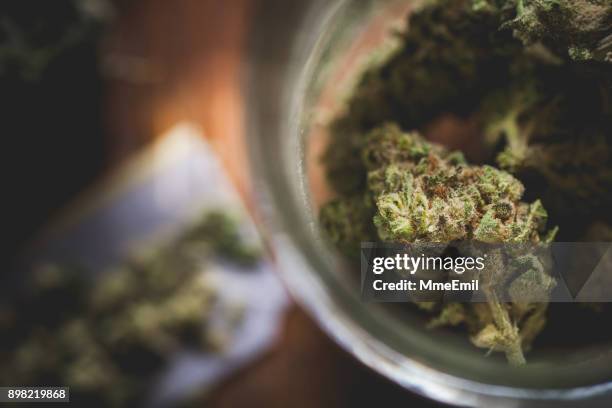 marihuana en un tarro. articulación del cannabis. médica o recreativas - marihuana hierba de cannabis fotografías e imágenes de stock