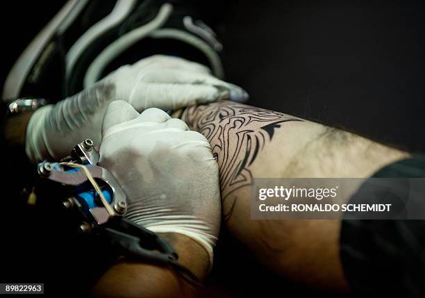 Tattoo artist works on August 15 during the International Convention of Tattoo at the World Trade Center in Mexico City. AFP PHOTO/Ronaldo Schemidt
