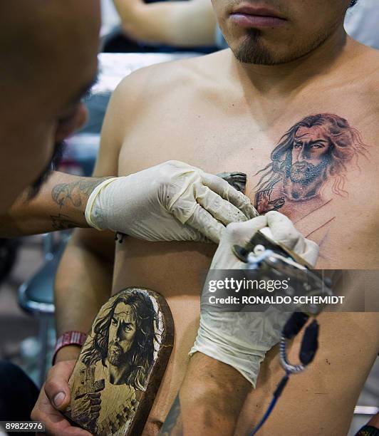 Tattoo artist works on August 15 during the International Convention of Tattoo at the World Trade Center in Mexico City. AFP PHOTO/Ronaldo Schemidt