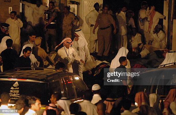 Kuwaiti rescue workers and security officials gather after a fire ripped through a packed wedding party in Jahra, west of Kuwait City, early on...