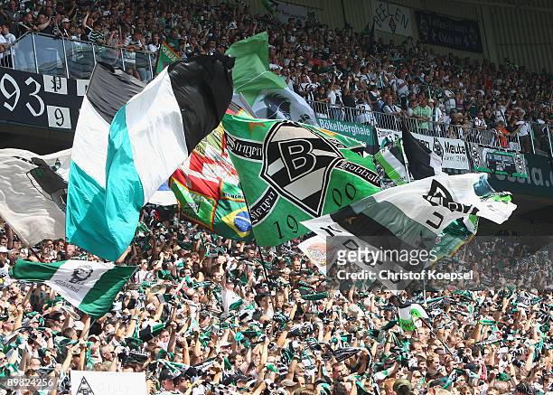 The fans of Gladbach wave flags during the Bundesliga match between Borussia Moenchengladbach and Hertha BSC Berlin at the Borussia Park on August...
