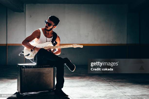 young afro american man playing electric guitar - electric guitar stock pictures, royalty-free photos & images