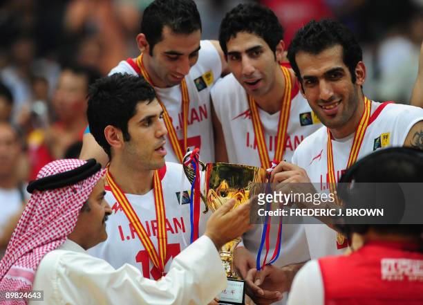 Asia President Sheikh Saud Ali Al Thani presents the championship trophy to Iran's Mohammadsamad Bahrami and Hamed Hadadi following victory over host...