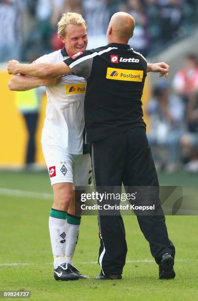 Tobias Levels of Moenchengladbach embraces head coach Michael Frontzeck after winning 2-1 the Bundesliga match between Borussia Moenchengladbach and...