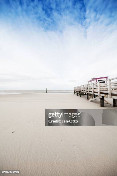 beach of st. peter-ording in germany with pile dwelling - st peter ording stock pictures, royalty-free photos & images