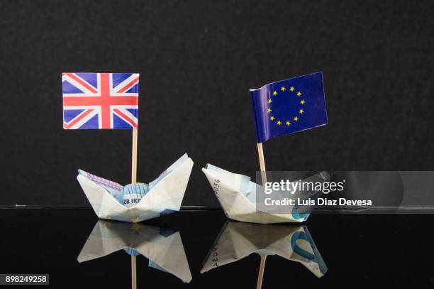 origami boats made with euro banknotes and their flags - brexit photos et images de collection