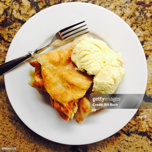 slice of hot apple pie with vanilla ice cream on a white plate with a fork - apple pie a la mode stock pictures, royalty-free photos & images