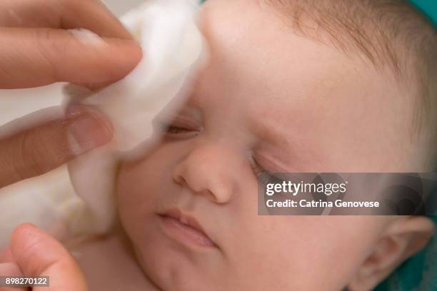 4 month old baby boy having face washed with soft cotton washcloth by father. - waschlappen stock-fotos und bilder