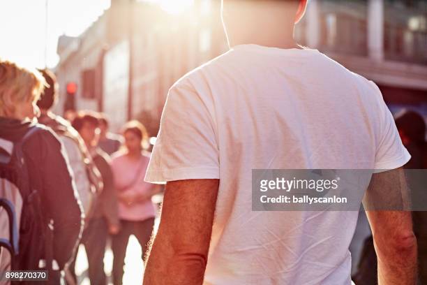 man walking on city street - plain t shirt stock pictures, royalty-free photos & images