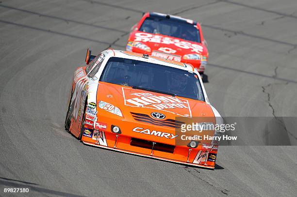Joey Logano, driver of the The Home Depot Toyota, leads Tony Stewart, driver of the Office Depot Chevrolet, during the NASCAR Sprint Cup Series...
