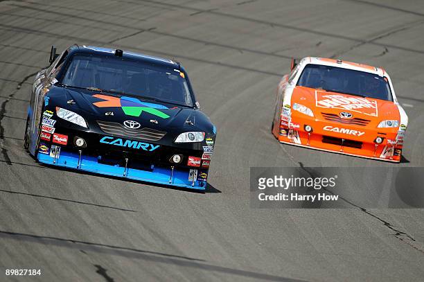 Denny Hamlin , driver of the FedEx Office Toyota, leads Joey Logano, driver of the The Home Depot Toyota, during the NASCAR Sprint Cup Series CARFAX...