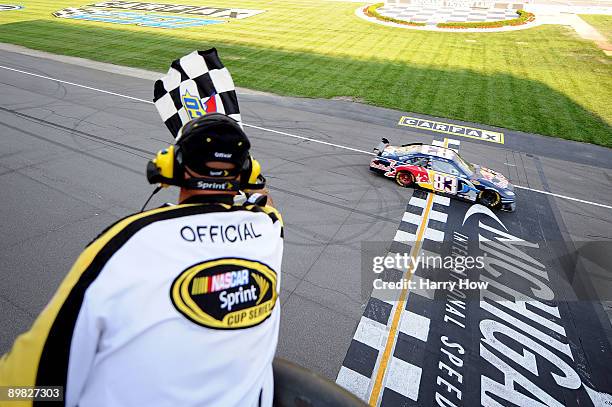 Brian Vickers, driver of the Red Bull Toyota, crosses the start/finish line to take the checkered flag and win at the NASCAR Sprint Cup Series CARFAX...