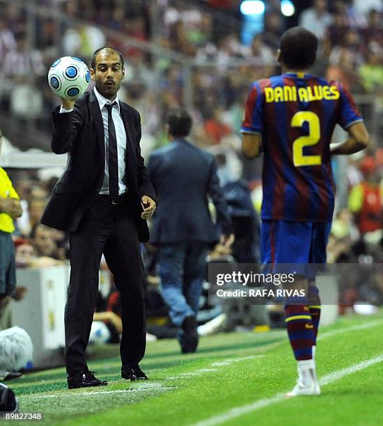 Barcelona's coach Pep Guardiola gives the ball to his player Dani Alves, during their Spanish Supercup 1st leg football match against Athletic...