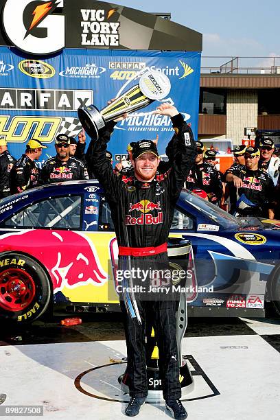 Brian Vickers, driver of the Red Bull Toyota, celebrates with the trophy in victory lane after winning the NASCAR Sprint Cup Series CARFAX 400 at...