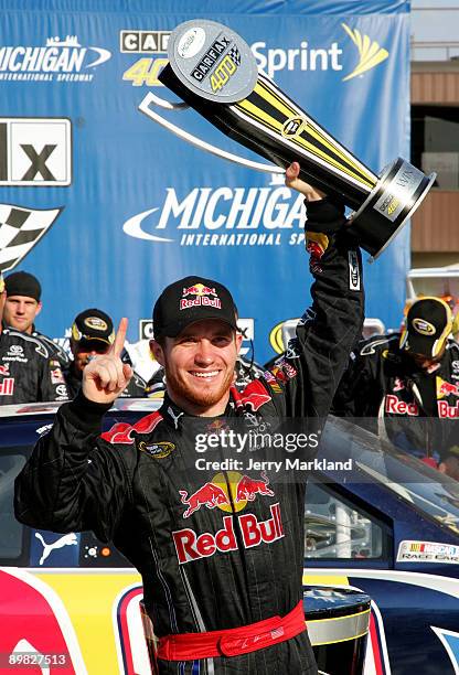 Brian Vickers, driver of the Red Bull Toyota, celebrates with the trophy in victory lane after winning the NASCAR Sprint Cup Series CARFAX 400 at...