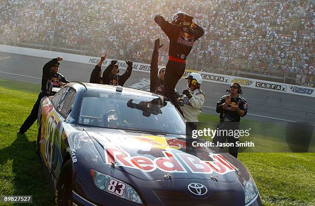 Brian Vickers, driver of the Red Bull Toyota, celebrates with team members after winning the NASCAR Sprint Cup Series CARFAX 400 at Michigan...