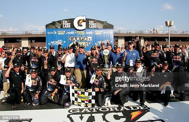 Brian Vickers, driver of the Red Bull Toyota, celebrates with his crew in victory lane during the NASCAR Sprint Cup Series CARFAX 400 at Michigan...