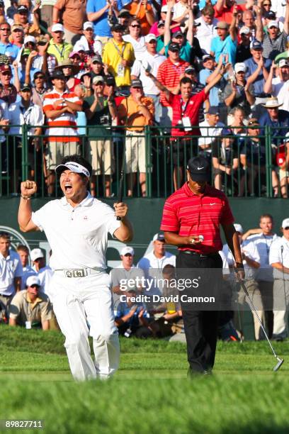 Yang of South Korea celebrates a birdie putt on the 18th green alongside Tiger Woods during the final round of the 91st PGA Championship at Hazeltine...