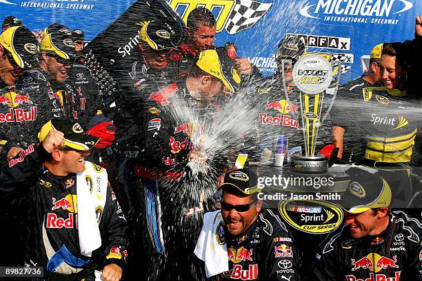 Brian Vickers, driver of the Red Bull Toyota, celebrates with his crew in victory lane after winning the NASCAR Sprint Cup Series CARFAX 400 at...