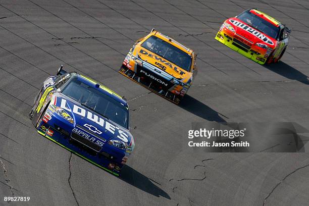 Jimmie Johnson, driver of the Lowe's Chevrolet races Matt Kenseth, driver of the DeWalt Ford and Jeff Gordon, driver of the DuPont Chevrolet during...