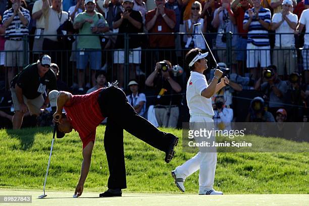 Yang of South Korea celebrates a birdie putt on the 18th green alongside Tiger Woods during the final round of the 91st PGA Championship at Hazeltine...