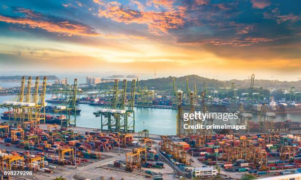 container cargo freight ship with working crane bridge in shipyard in singapore - singapore port stock pictures, royalty-free photos & images