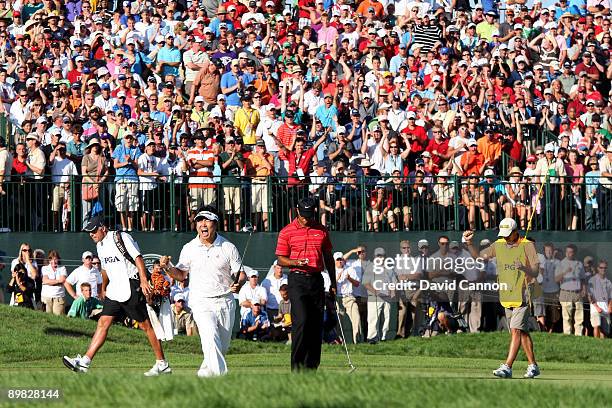 Yang of South Korea celebrates a birdie putt on the 18th green alongside Tiger Woods during the final round of the 91st PGA Championship at Hazeltine...